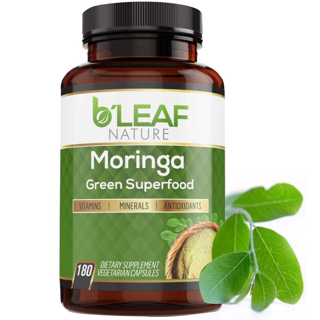 A bottle of B'Leaf Nature moringa with a few moringa plant leaves next to it.